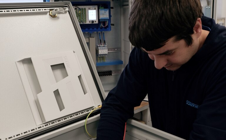 Ein NIVUS Mitarbeiter konfektioniert einen Schaltschrank für die schlüsselfertige Installation der Messtechnik