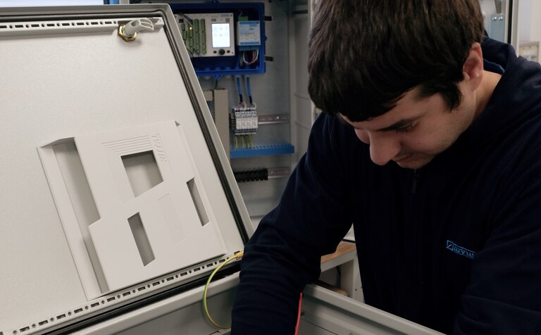 Ein NIVUS Mitarbeiter konfektioniert einen Schaltschrank für die schlüsselfertige Installation der Messtechnik